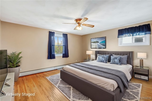 bedroom with baseboard heating, light wood-style floors, baseboards, and a ceiling fan