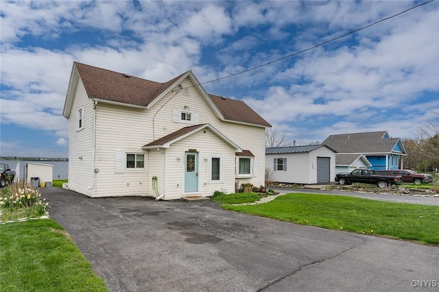 17869 County Route 59, Brownville, NY 13634 - view of front of home featuring a front yard, roof with shingles, and asphalt driveway