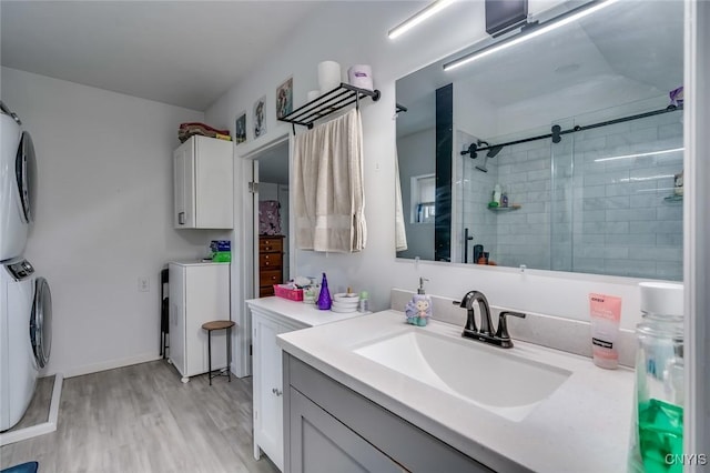 17869 County Route 59, Brownville, NY 13634 - bathroom featuring a shower stall, wood finished floors, vanity, and stacked washing machine and dryer