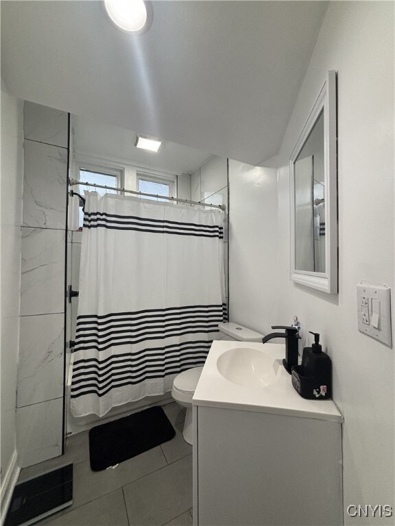 bathroom with vanity, toilet, and tile patterned flooring