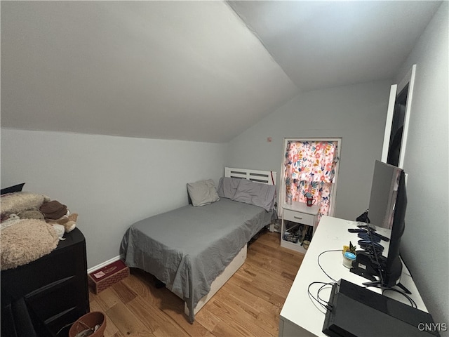 bedroom featuring lofted ceiling and light wood-style floors