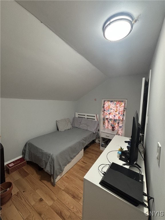 bedroom featuring lofted ceiling and light wood finished floors