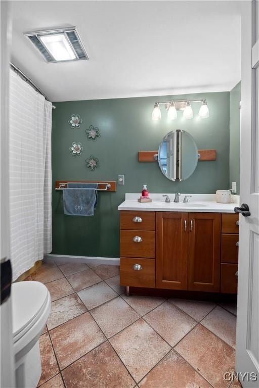 bathroom with baseboards, vanity, and toilet