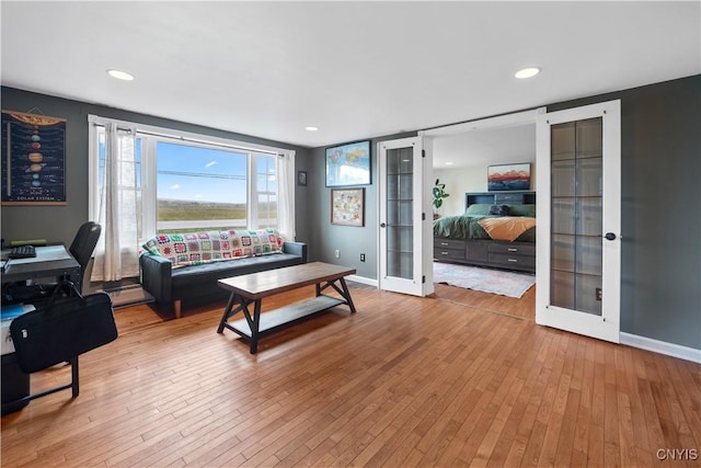 living room featuring french doors, wood-type flooring, and baseboards