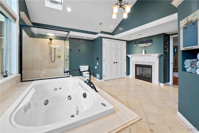 bathroom with lofted ceiling, a shower stall, a glass covered fireplace, a whirlpool tub, and tile patterned floors