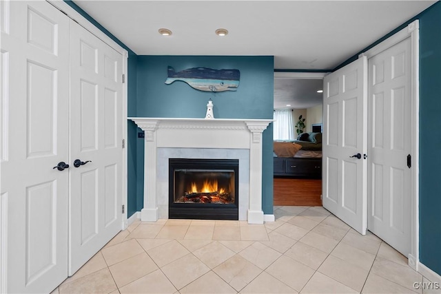 detailed view of a lit fireplace, baseboards, and recessed lighting