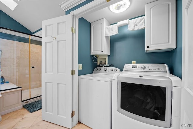 clothes washing area featuring independent washer and dryer, cabinet space, light tile patterned flooring, and a skylight