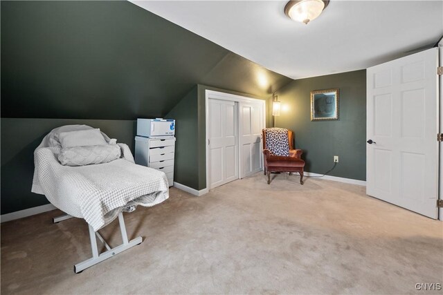 living area with baseboards, light colored carpet, and vaulted ceiling