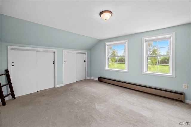 additional living space with a baseboard radiator, lofted ceiling, and carpet floors