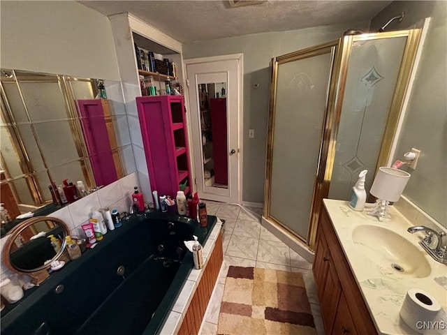 full bathroom featuring a shower stall, a jetted tub, vanity, and a textured ceiling