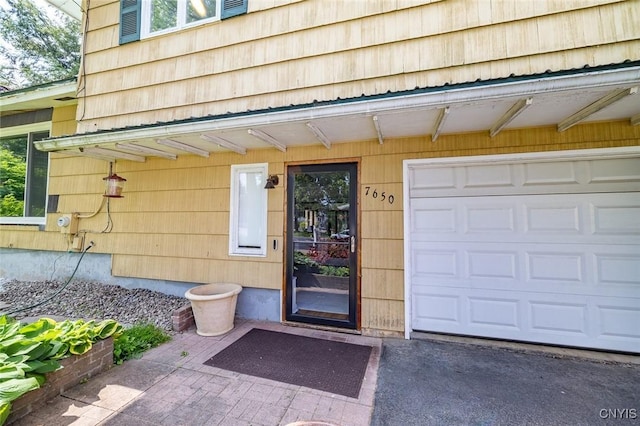 7650 Commodore Cir, Clay, NY 13090 - doorway to property with a garage and asphalt driveway