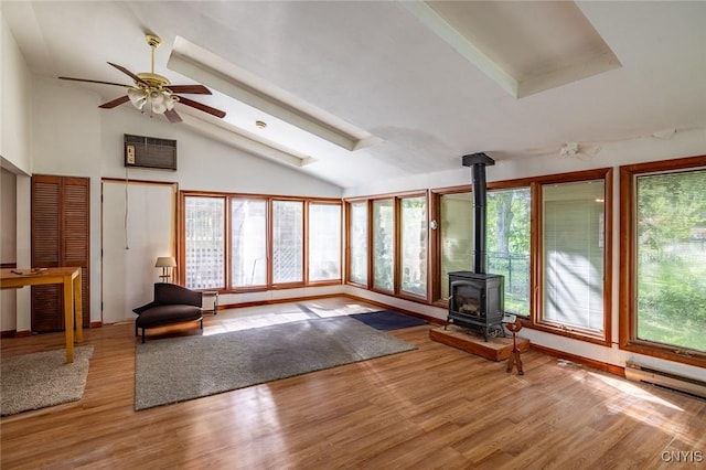 7650 Commodore Cir, Clay, NY 13090 - unfurnished living room with a wood stove, vaulted ceiling, plenty of natural light, wood finished floors, and a ceiling fan