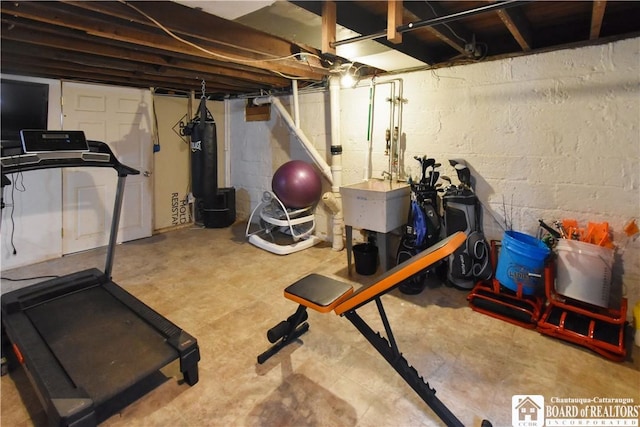 workout area with a sink and concrete block wall