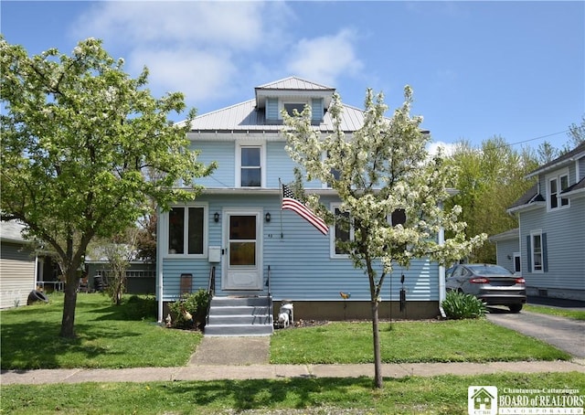 traditional style home with metal roof and a front yard