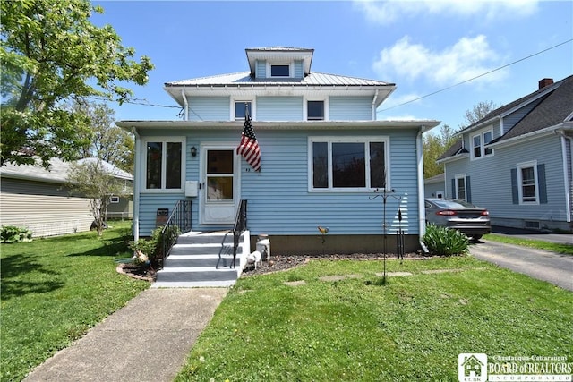 american foursquare style home with a front yard and metal roof