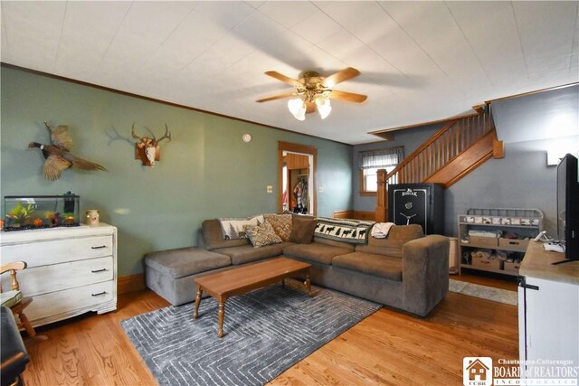 living area with a ceiling fan and wood finished floors