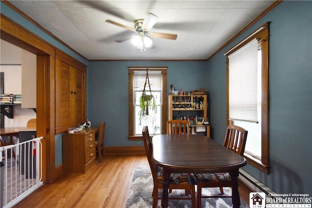 dining room with ceiling fan, light wood-style floors, crown molding, and baseboards