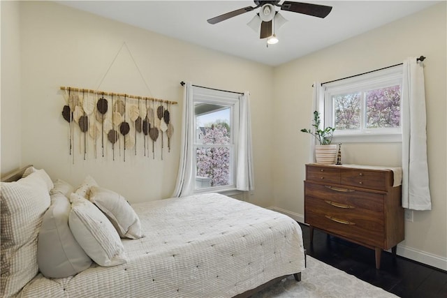 bedroom featuring baseboards, wood finished floors, and ceiling fan