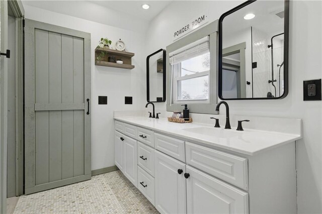 full bath featuring double vanity, a stall shower, recessed lighting, tile patterned floors, and baseboards