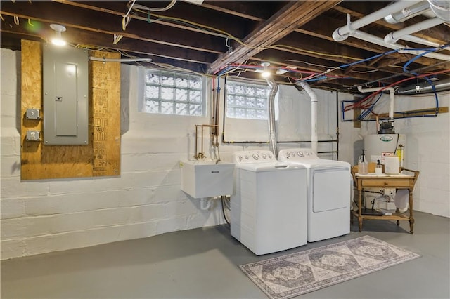 laundry room featuring electric panel, washer and clothes dryer, and gas water heater