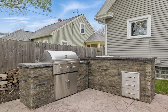 view of patio / terrace with area for grilling, an outdoor kitchen, and fence