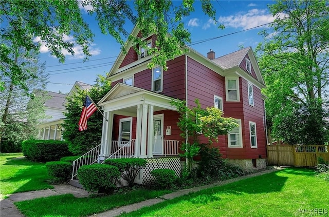 view of front facade featuring covered porch and a chimney