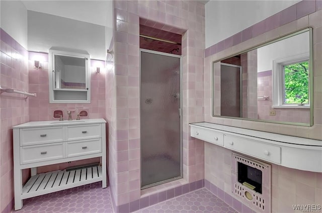 bathroom featuring tile walls, a shower stall, and vanity