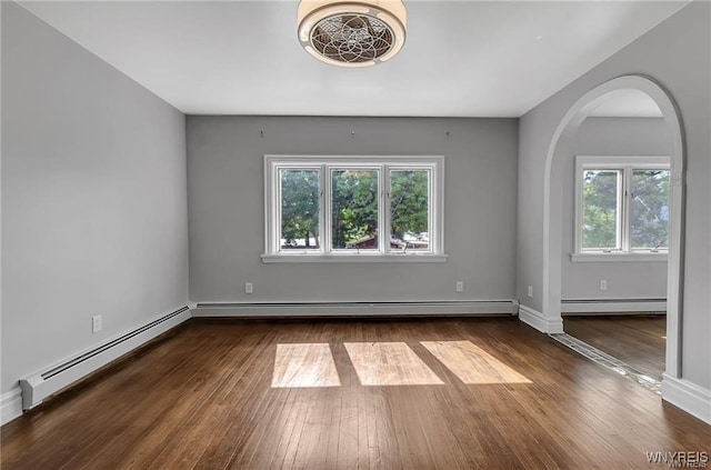 empty room with baseboard heating and hardwood / wood-style floors