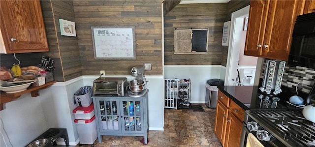 43 Sunnyside Dr, Elmira, NY 14905 - kitchen featuring wooden walls, stone finish flooring, brown cabinetry, baseboards, and black microwave
