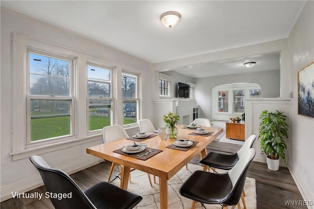 329 Jewett Ave, Buffalo, NY 14214 - dining area featuring baseboards, wood finished floors, and arched walkways