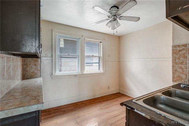 329 Jewett Ave, Buffalo, NY 14214 - kitchen with a sink, light wood finished floors, a ceiling fan, baseboards, and tasteful backsplash