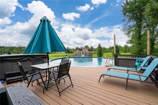 29441 Beaver Meadow Mews, Lyme, NY 13622 - swimming pool featuring a deck, a hot tub, an outbuilding, and outdoor dining area