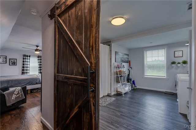 29441 Beaver Meadow Mews, Lyme, NY 13622 - bedroom with a barn door, dark wood-style flooring, and baseboards