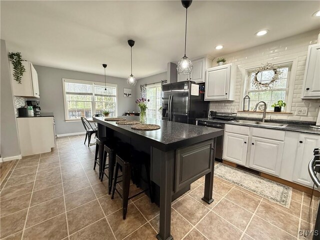 29441 Beaver Meadow Mews, Lyme, NY 13622 - kitchen featuring stainless steel appliances, dark countertops, a sink, tasteful backsplash, and recessed lighting