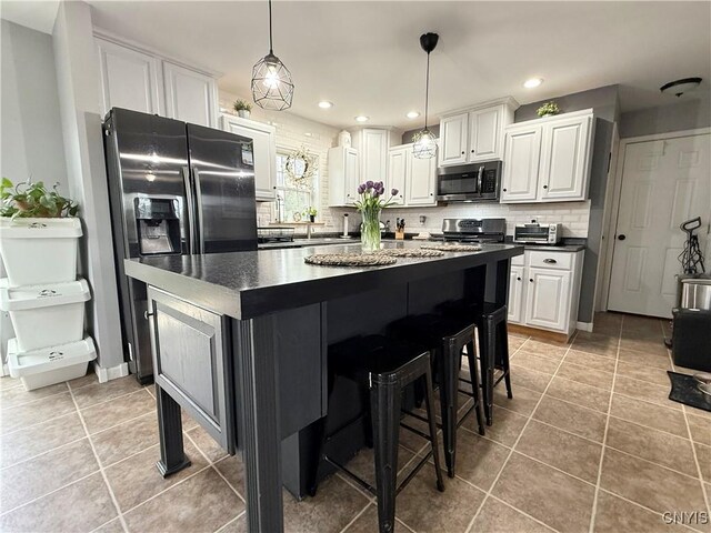 29441 Beaver Meadow Mews, Lyme, NY 13622 - kitchen featuring appliances with stainless steel finishes, dark countertops, a kitchen island, white cabinets, and recessed lighting