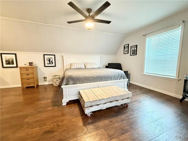 29441 Beaver Meadow Mews, Lyme, NY 13622 - bedroom with vaulted ceiling, dark wood-style flooring, baseboards, a ceiling fan, and a wood stove