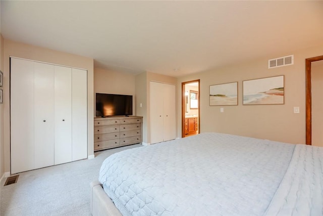 bedroom with multiple closets, light colored carpet, and baseboards