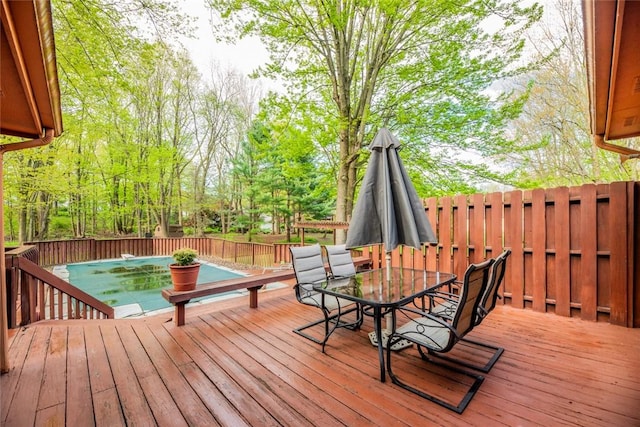deck featuring outdoor dining area and a fenced backyard