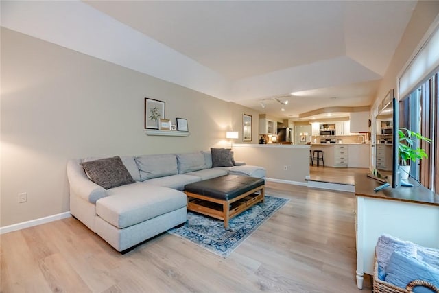 living area with light wood finished floors and baseboards