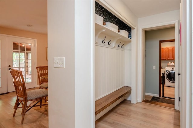 mudroom with independent washer and dryer, light wood-style flooring, french doors, and baseboards