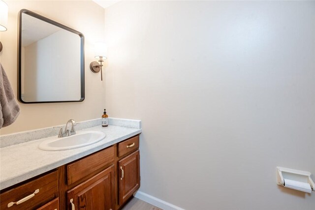 bathroom with vanity, baseboards, and wood finished floors