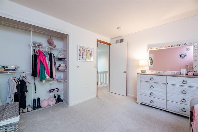 bedroom featuring a closet, light carpet, and baseboards