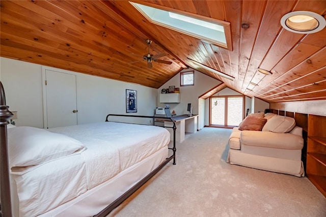 bedroom with wood ceiling, vaulted ceiling, a skylight, and light carpet