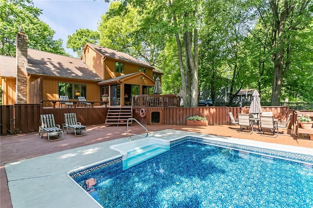 view of swimming pool with a deck, fence, and a patio