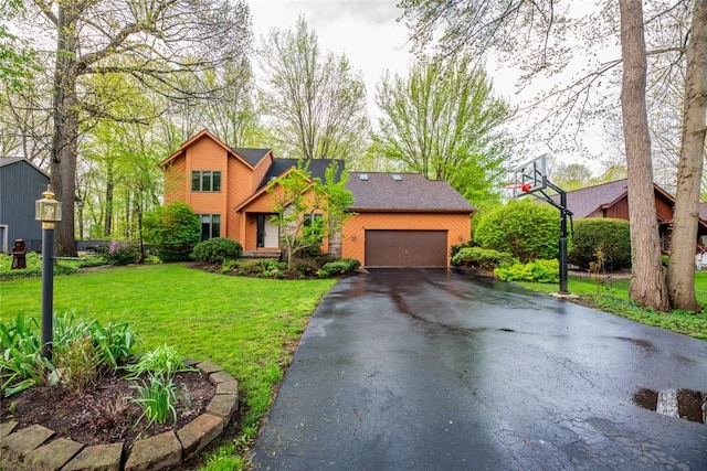 view of front of home featuring asphalt driveway, a front lawn, and a garage