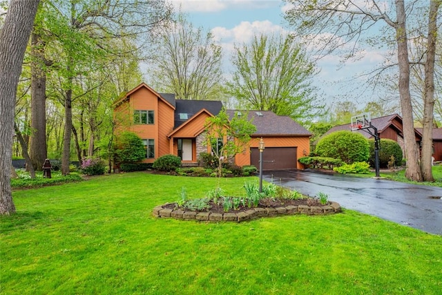 view of front of home with driveway, an attached garage, and a front lawn