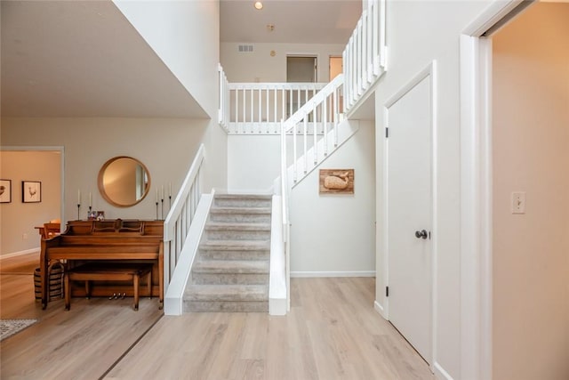 stairs featuring wood finished floors and baseboards