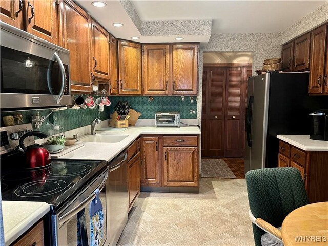 kitchen with stainless steel appliances, light countertops, recessed lighting, a sink, and light flooring