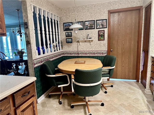 dining space featuring a chandelier and baseboards