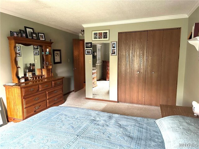 bedroom featuring ornamental molding, carpet flooring, a textured ceiling, and a closet